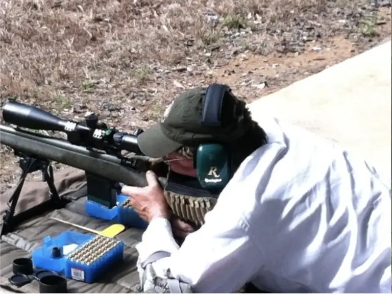 An F-Class shooter at a scoped rifle on the firing line