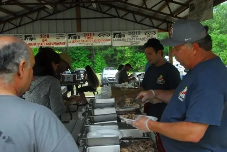 Competitors at the match sign-in table under the pavilion