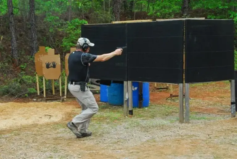 An IDPA competitor shooting a stage with barricades