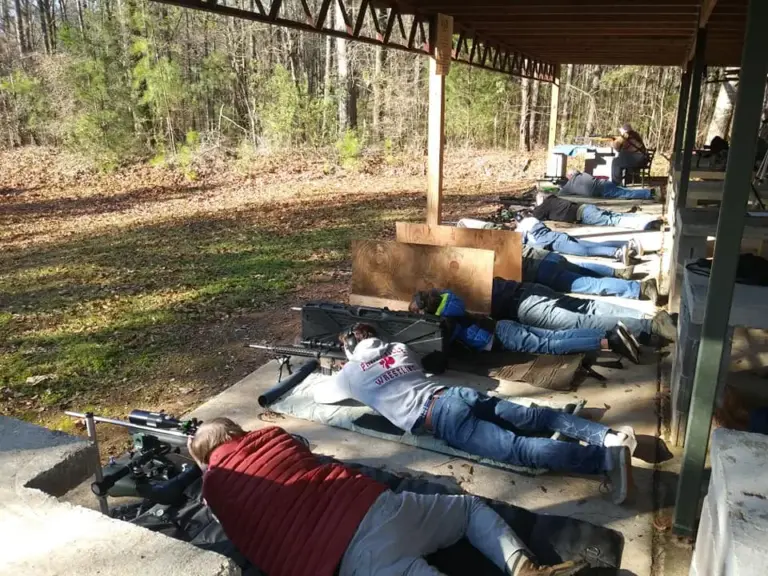 Shooters at the benches of the covered rifle range